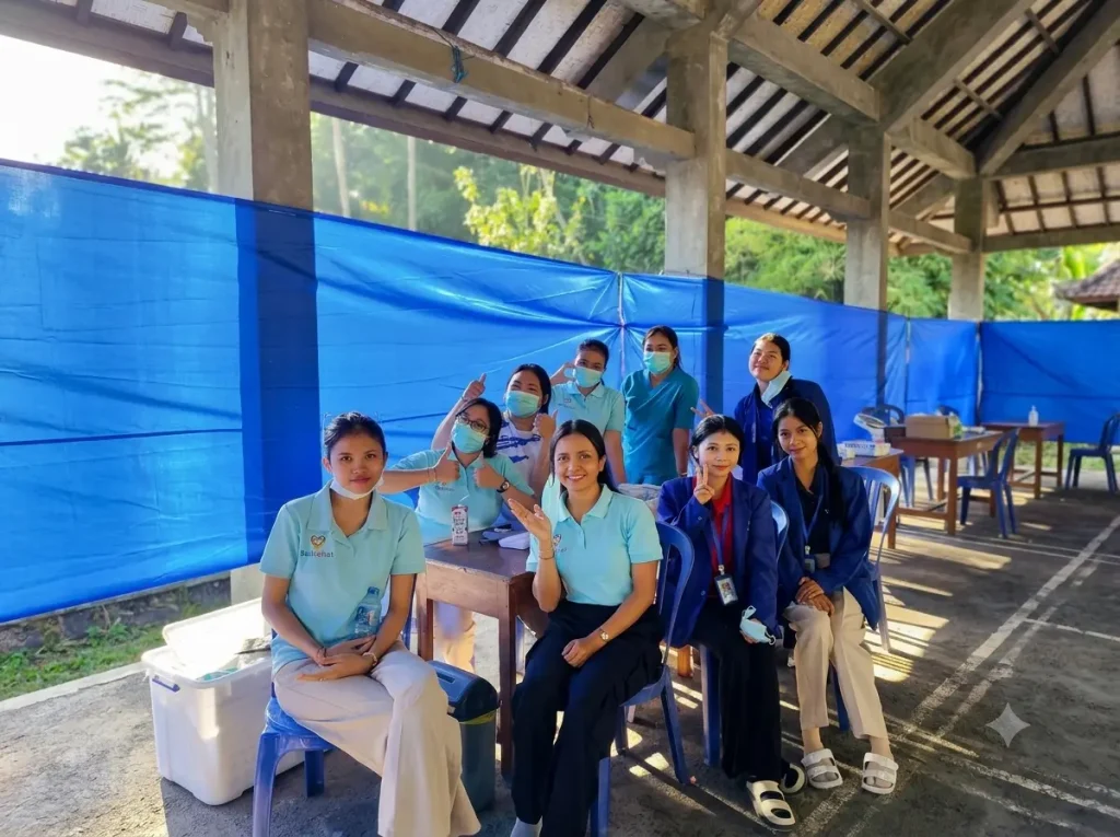Bali Sehat Clinic staff and Alfa Prima on-job training students posing together during Healthy Day in Desa Kesimpar