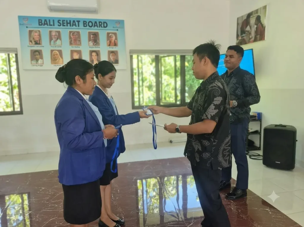 Bali Sehat Clinic management receiving on-job training documents from Alfa Prima Karangasem students