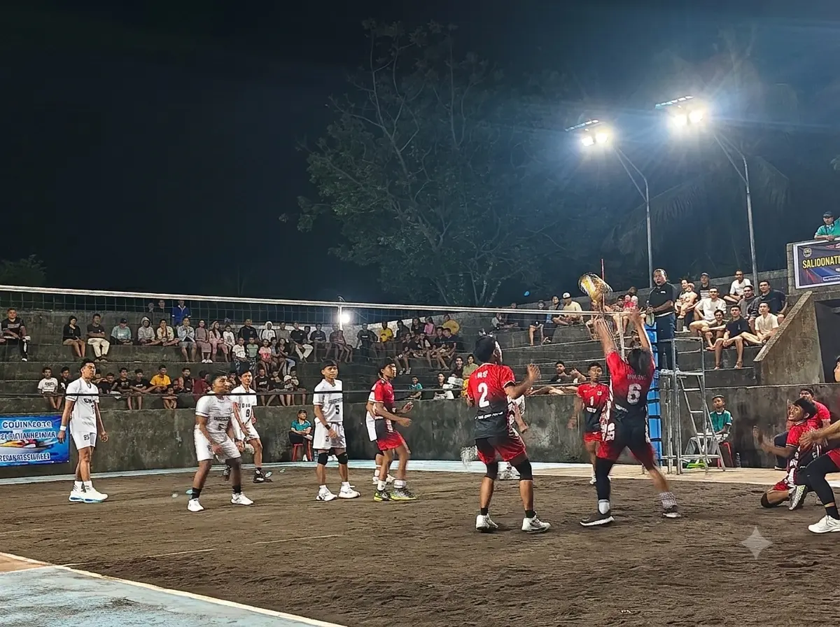 Two teams compete in a night volleyball match during PORDES Desa Culik 2026 as a crowd watches from the stands