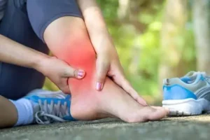 Person holding their ankle in pain after a sprain injury