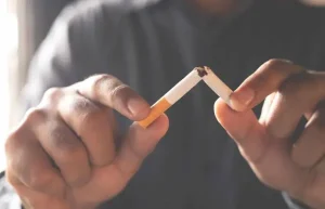 Man breaking a cigarette in half as a symbol of quitting smoking