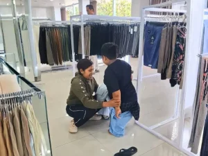 Volunteer helping child with disability in Bali try on new clothes
