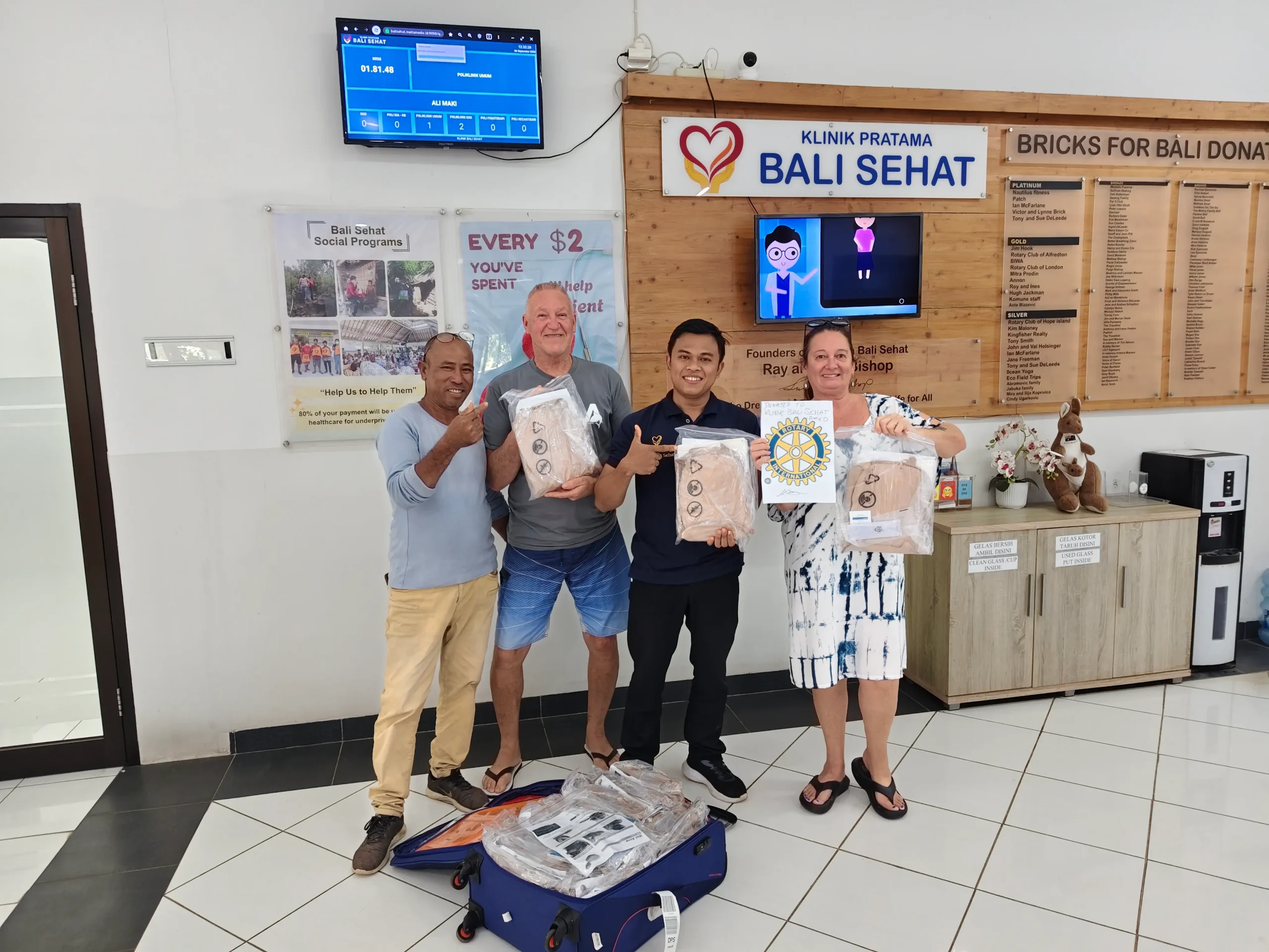 Rotary Club representatives handing over 30 CPR training manikins to Bali Sehat clinic staff at the reception area in Amed, East Bali
